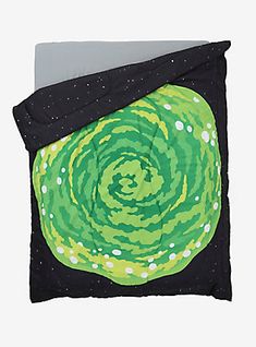 a green and black comforter on top of a bed next to a white pillow