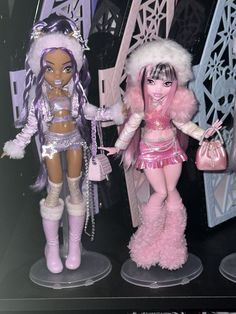 two barbie dolls standing next to each other