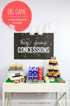 a white table topped with cakes and cupcakes next to a chalkboard sign