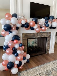 a bunch of balloons that are in front of a fire place with a television on