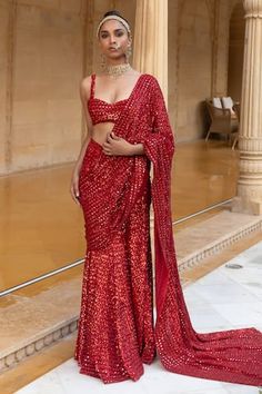 Red pre-draped saree with mirror, cutdana, sequin embroidery in geometric pattern. Paired with sweetheart neck embroidered blouse.
Components: 2
Pattern: Embroidery
Type Of Work: Mirror, cutdana, sequin
Neckline: Sweetheart neck
Sleeve Type: Sleeveless
Fabric: Georgette
Color: Red
Other Details: 
Back deep square neck
Occasion: Bride,Reception - Aza Fashions Pre-draped Saree With Mirror Work For Diwali, Draped Saree For Evening Festivals, Diwali Pre-draped Saree With Mirror Work, Evening Saree For Festivals, Draped Style, Evening Pre-draped Fitted Saree With Mirror Work, Evening Saree For Festivals, Diwali Saree With Mirror Work And Draped Shape, Festival Evening Pre-draped Saree, Festive Pre-draped Saree With Side Open