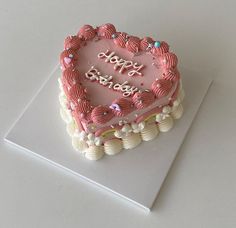 a heart shaped birthday cake sitting on top of a table