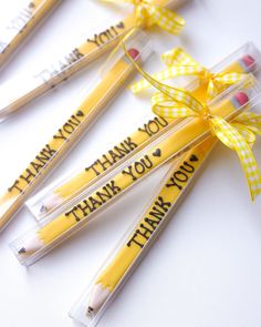 four pencils with thank you written on them and tied in yellow ribbon, sitting next to each other