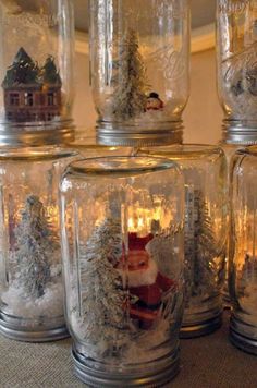 there are many glass jars with christmas decorations in them