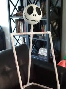 a skeleton sitting on top of a black couch