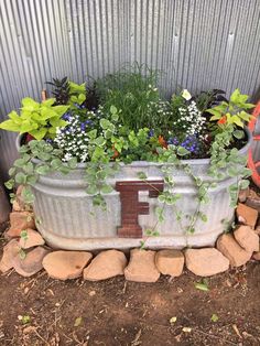 a metal tub filled with flowers and plants