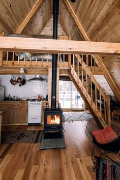 a stove in the middle of a wooden floored room with stairs leading up to it