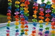 multicolored paper flowers are hanging in the pool