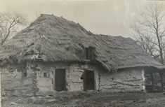 an old black and white photo of a thatched house