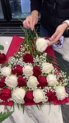 someone is arranging flowers on a table