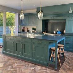 a kitchen with green cabinets and wooden floors