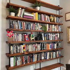 a bookshelf filled with lots of books in a living room