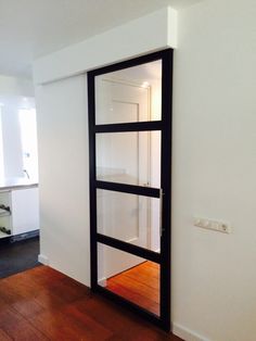 an empty room with a large mirror on the wall and wood flooring in front of it