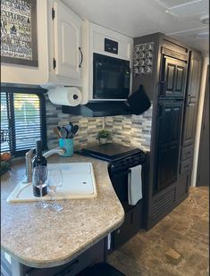 a kitchen with black and white appliances and marble counter tops in the middle of it