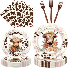 a set of plates with a cow head on it and two forks next to each other