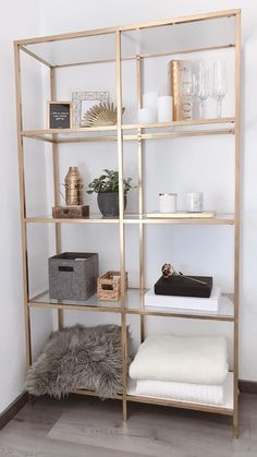 a shelving unit in a room with white walls and wood shelves, filled with decorative items