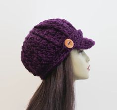 This is made to order. It is crocheted with chunky medium to dark purple acrylic yarn. Buttons will vary depending on availability. Hand wash is recommended. Purple Hand Knitted Brimmed Hat, Adjustable Hand Knitted Purple Crochet Hat, Adjustable Hand-knitted Purple Crochet Hat, Adjustable Purple Yarn Crochet Hat, Adjustable Purple Crochet Yarn Hat, Adjustable Purple Crochet Hat, Adjustable Purple Hand Knitted Crochet Hat, Purple Yarn Cap, Purple Hand Knitted Crochet Cap