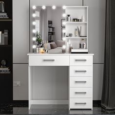 a white vanity with lights on it next to a couch and bookshelf in a room