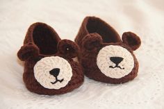 a pair of brown and white crocheted shoes with a bear's face