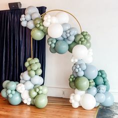 an arch made out of balloons on top of a wooden floor