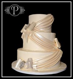 a three tiered wedding cake with bows and ribbons