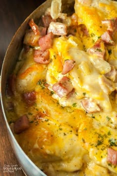 a casserole dish with ham and cheese in a pan on a wooden table