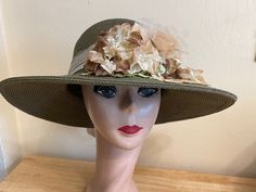 This one of a kind dark Khaki green 4 inch brim Toyo Straw hat is trimmed with a large beige silk rose  and small organza flowers. The leaves are assorted velvet and the band is bronze organza ribbon tied in a bow in back. The outside band can tighten to adjust the head size. The hat will fit 22- 22 5/8 inch head sizes.  NOTE: Please check the head size before purchase, I am happy to answer any questions you may have. There will be a 20% restocking fee for all returned hats. Green Short Brim Sun Hat For Kentucky Derby, Green Brimmed Sun Hat For Kentucky Derby, Brown Hats For Kentucky Derby Garden Party, Handmade Green Hat For Party, Green Brimmed Hat For Races, Green Short Brim Hat For Garden Party, Green Wide Brim Sun Hat For Garden Party, Beige Silk, Organza Flowers