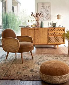 a living room with two chairs and a rug on the floor in front of a dresser