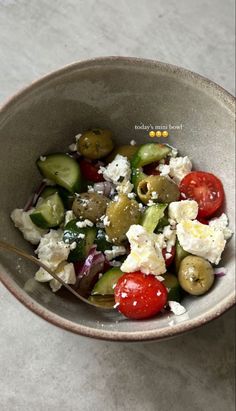 a bowl filled with cucumbers, tomatoes and feta cheese