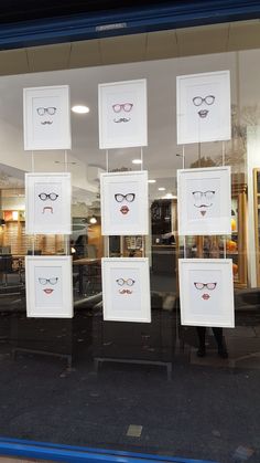 a store front window with framed glasses and mustaches