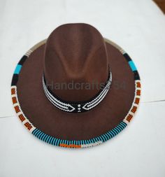 This listing is for beaded edge and brim fedora hat. The beads go around the whole edge and brim. The brim band is removable and can therefore be used on another hat. Most hat brims are one size fits all.I have made a beautiful pattern that goes all round. Instead of having a plain fedora hat, this one is more beautiful with beads. The hat is size 57. You can select a different color for the fedora hat but the beads color and pattern remains the same as shown on the photo. I ship via DHL express Beaded Brown Hat Band For Festival, Beaded Brown Hat Bands For Festival, Festival Brown Beaded Hat Bands, Handmade Brown Fedora With Short Brim, Traditional Brown Beaded Hat Bands, Traditional Brown Fedora Hat, Brown Handmade Fedora With Short Brim, Traditional Handmade Brown Hat Bands, Beaded Brown Wide Brim Hat