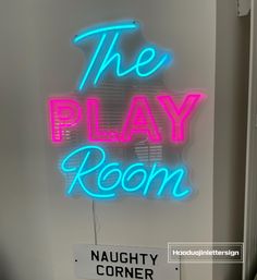 a neon sign that reads the play room