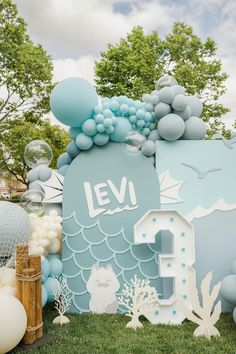 an ocean themed birthday party with balloons and paper cutouts on the front, under a cloudy blue sky