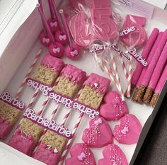 pink and white heart shaped cookies in a box with straws on the table next to them