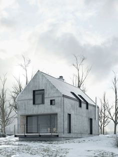 the house is surrounded by snow and bare trees