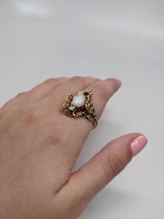 This ring is 14k yellow gold. The piece was handmade by our jeweler back in the 90s. The Tennessee Pearl is prong set. The middle of the pearl has a small diamond set in it. The piece is accented with two other diamonds. The total weight of diamond is 0.25 carat. Size 10.5, but can be resized up or down two sizes free of charge. The face of the ring is 23x15mm. Originally $2500, but is now on sale for $2000. Heirloom Gold Opal Ring With Diamond Accents, 14k Yellow Gold Pearl Ring With Center Stone, Victorian Pearl Ring With Gold And Diamond, Gold Heirloom Pearl Ring With Center Stone, Unique 14k Yellow Gold Pearl Ring, Heirloom Gold Pearl Ring With Center Stone, Heirloom 14k Gold Pearl Ring With Rose Cut Diamonds, Unique 14k Gold Pearl Wedding Ring, Unique 14k Gold Pearl Ring For Wedding