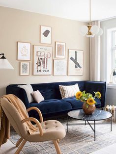 a living room with blue couches and pictures on the wall above it's coffee table