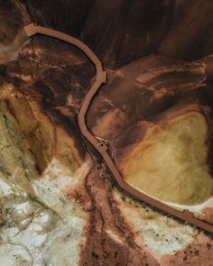 an aerial view of a winding road in the middle of a mountainous area with rocks and dirt