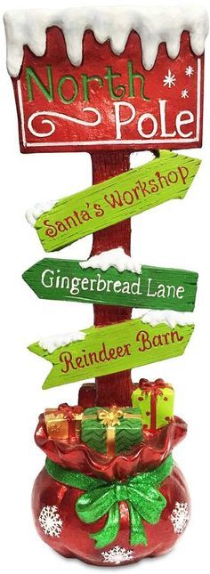 a christmas ornament with signs in the shape of santa's workshop and gingerbread lane