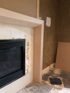 an unfinished room with a fire place in the corner and drywall on the floor