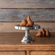 some pears are sitting on a silver plate