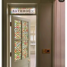 an open door leading to a bathroom with stained glass panels on the front and side