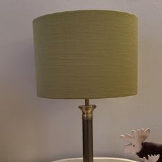 a lamp on a table with a moose figurine next to it and a green lampshade