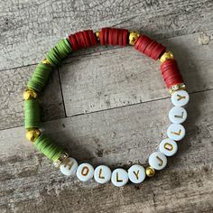 a beaded bracelet with the word holly written in white and gold letters on it