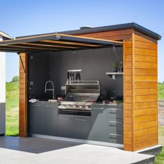 an outdoor kitchen is built into the side of a building with a grill and sink