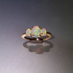 3 gorgeous solid opals, set in a 14ct yellow gold ring. Opal  Weight: 1.15ct Size: 2x 5x4mm and 1x 8x6mm Ring size AUS: P US: 8 Band diameter: 18.4mm Band width: 1.8-2mm Materials: Solid opals, 14ct yellow gold Total weight: 3.4gm Opal Three-stone Ring For Anniversary, Elegant Yellow Gold Three Stone Opal Ring, Anniversary Three Stone Opal Ring, Gold Opal Three-stone Oval Ring, Gold Oval Three-stone Opal Ring, Gold Oval Three Stone Opal Ring, Gold Oval Opal Ring With Three Stones, Yellow Gold Three Stone Opal Ring Gift, Gift Yellow Gold Three Stone Opal Ring