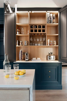 a kitchen with blue cabinets and white counter tops, two lemons on the island