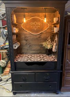 an old fashioned display case with lights on it's sides and drawers in the middle