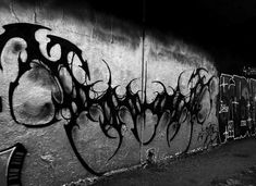 black and white photograph of graffiti on a wall