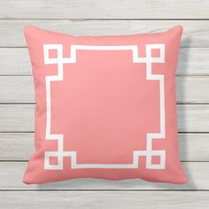 a pink and white pillow on a wooden wall with an empty square in the middle